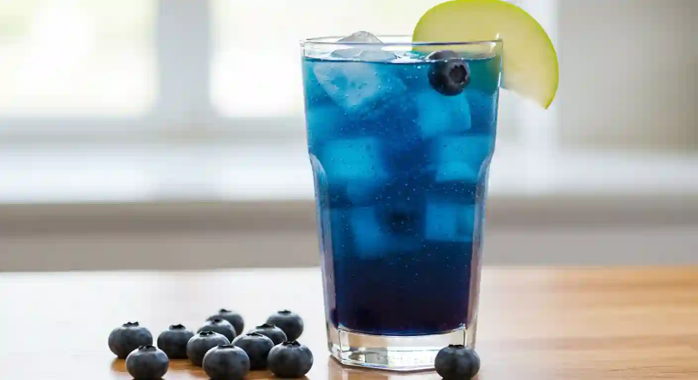 Blueberry-loaded tea with a mix of fruits and ice, served in a tall glass with fresh blueberries and a lime slice.